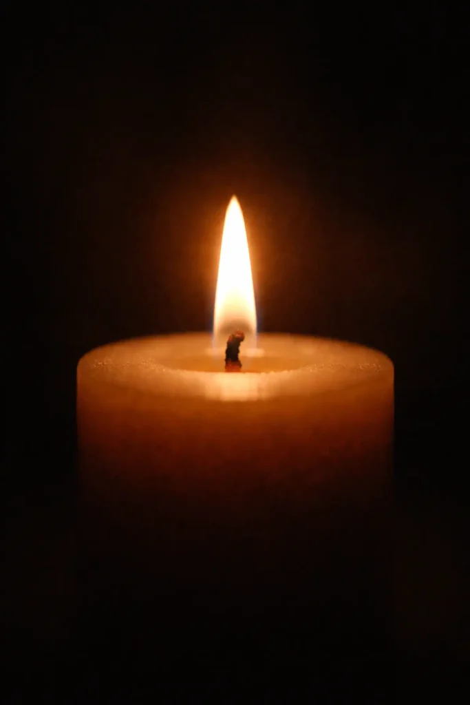 Flamme de bougie immobile dans l’obscurité, symbole de la colère contenue et de la régulation émotionnelle chez un parent avant de réagir